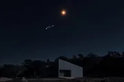 Arcturus, an orange point high above a dark treeline, trailing the handle of the Big Dipper