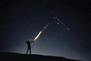 An archer silhouetted on a dark ridge draws a bow toward Orion, red Betelgeuse glowing at the Hunter's shoulder