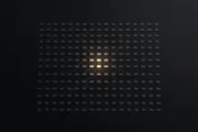 Hundreds of identical small tiles fading into the dark, with only a handful at the center lit in warm amber and connected by faint lines, evoking a sprawling system reducing to a few core primitives