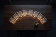 A desk at night with glowing terminal panels fanned out like a conductor's score, the parallel work of directing AI agents