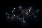 A constellation of small glowing nodes connected by light in the dark, evoking independent services working as one system