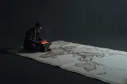 A lone figure working at a glowing forge on the edge of an uncharted map