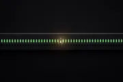 A dark instrument panel with a row of green lamps, one of them cracked and empty but still showing green