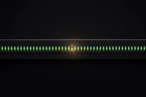 A dark instrument panel with a row of green lamps, one of them cracked and empty but still showing green