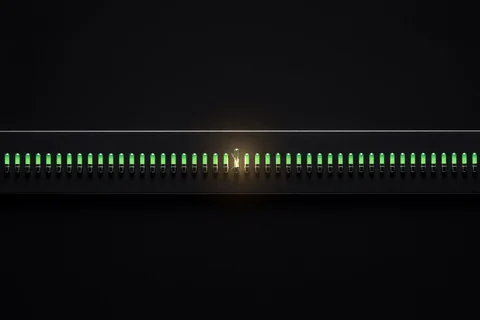 A dark instrument panel with a row of green lamps, one of them cracked and empty but still showing green