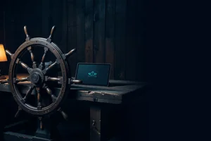 A wooden ship's wheel in a dark workshop beside a small screen showing a simple teal vector spaceship